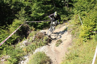 INNSBRUCK, AUSTRIA - 29 Ağustos 2015: Nordkette Alp dağ zincirinde Nordkette Downhill Pro yarışması sırasında tam donanımlı profesyonel motorcu dağ bisikleti sürüyor.