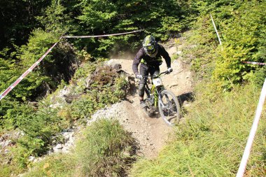 INNSBRUCK, AUSTRIA - 29 Ağustos 2015: Nordkette Alp dağ zincirinde Nordkette Downhill Pro yarışması sırasında tam donanımlı profesyonel motorcu dağ bisikleti sürüyor.
