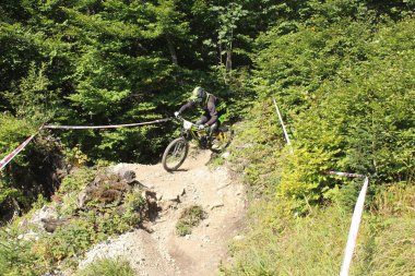 INNSBRUCK, AUSTRIA - 29 Ağustos 2015: Nordkette Alp dağ zincirinde Nordkette Downhill Pro yarışması sırasında tam donanımlı profesyonel motorcu dağ bisikleti sürüyor.