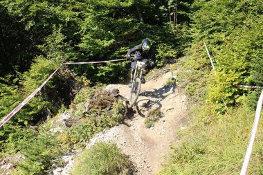 INNSBRUCK, AUSTRIA - 29 Ağustos 2015: Nordkette Alp dağ zincirinde Nordkette Downhill Pro yarışması sırasında tam donanımlı profesyonel motorcu dağ bisikleti sürüyor.