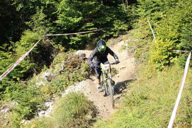 INNSBRUCK, AUSTRIA - 29 Ağustos 2015: Nordkette Alp dağ zincirinde Nordkette Downhill Pro yarışması sırasında tam donanımlı profesyonel motorcu dağ bisikleti sürüyor.