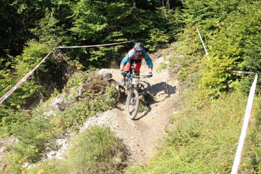 INNSBRUCK, AUSTRIA - 29 Ağustos 2015: Nordkette Alp dağ zincirinde Nordkette Downhill Pro yarışması sırasında tam donanımlı profesyonel motorcu dağ bisikleti sürüyor.
