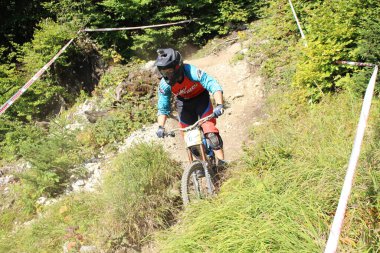 INNSBRUCK, AUSTRIA - 29 Ağustos 2015: Nordkette Alp dağ zincirinde Nordkette Downhill Pro yarışması sırasında tam donanımlı profesyonel motorcu dağ bisikleti sürüyor.