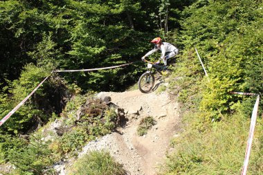 INNSBRUCK, AUSTRIA - 29 Ağustos 2015: Nordkette Alp dağ zincirinde Nordkette Downhill Pro yarışması sırasında tam donanımlı profesyonel motorcu dağ bisikleti sürüyor.