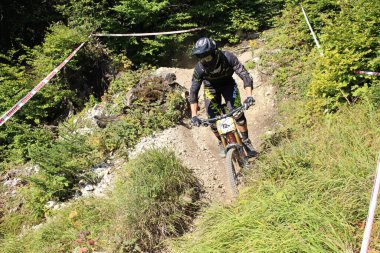 INNSBRUCK, AUSTRIA - 29 Ağustos 2015: Nordkette Alp dağ zincirinde Nordkette Downhill Pro yarışması sırasında tam donanımlı profesyonel motorcu dağ bisikleti sürüyor.