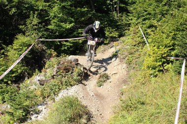 INNSBRUCK, AUSTRIA - 29 Ağustos 2015: Nordkette Alp dağ zincirinde Nordkette Downhill Pro yarışması sırasında tam donanımlı profesyonel motorcu dağ bisikleti sürüyor.