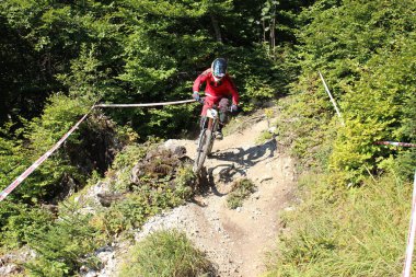 INNSBRUCK, AUSTRIA - 29 Ağustos 2015: Nordkette Alp dağ zincirinde Nordkette Downhill Pro yarışması sırasında tam donanımlı profesyonel motorcu dağ bisikleti sürüyor.