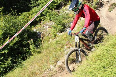 INNSBRUCK, AUSTRIA - 29 Ağustos 2015: Nordkette Alp dağ zincirinde Nordkette Downhill Pro yarışması sırasında tam donanımlı profesyonel motorcu dağ bisikleti sürüyor.