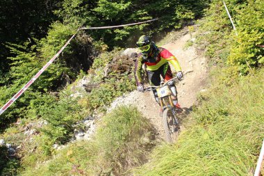 INNSBRUCK, AUSTRIA - 29 Ağustos 2015: Nordkette Alp dağ zincirinde Nordkette Downhill Pro yarışması sırasında tam donanımlı profesyonel motorcu dağ bisikleti sürüyor.