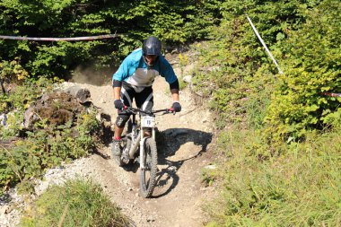 INNSBRUCK, AUSTRIA - 29 Ağustos 2015: Nordkette Alp dağ zincirinde Nordkette Downhill Pro yarışması sırasında tam donanımlı profesyonel motorcu dağ bisikleti sürüyor.