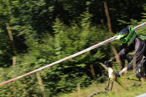 INNSBRUCK, AUSTRIA - 29 Ağustos 2015: Nordkette Alp dağ zincirinde Nordkette Downhill Pro yarışması sırasında tam donanımlı profesyonel motorcu dağ bisikleti sürüyor.