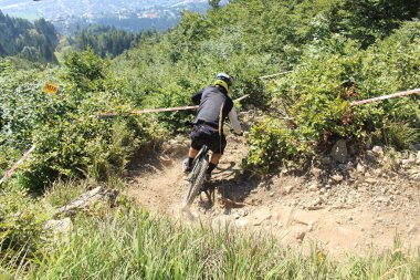 INNSBRUCK, AUSTRIA - 29 Ağustos 2015: Nordkette Alp dağ zincirinde Nordkette Downhill Pro yarışması sırasında tam donanımlı profesyonel motorcu dağ bisikleti sürüyor.