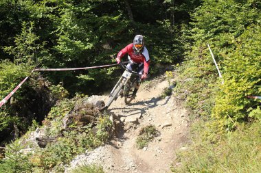 INNSBRUCK, AUSTRIA - 29 Ağustos 2015: Nordkette Alp dağ zincirinde Nordkette Downhill Pro yarışması sırasında tam donanımlı profesyonel motorcu dağ bisikleti sürüyor.