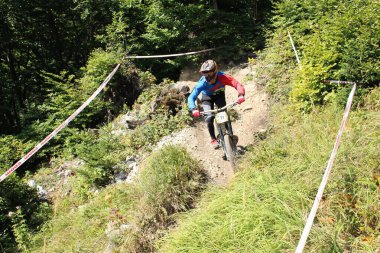 INNSBRUCK, AUSTRIA - 29 Ağustos 2015: Nordkette Alp dağ zincirinde Nordkette Downhill Pro yarışması sırasında tam donanımlı profesyonel motorcu dağ bisikleti sürüyor.