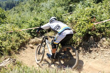 INNSBRUCK, AUSTRIA - 29 Ağustos 2015: Nordkette Alp dağ zincirinde Nordkette Downhill Pro yarışması sırasında tam donanımlı profesyonel motorcu dağ bisikleti sürüyor.