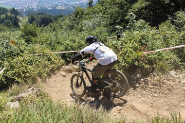 INNSBRUCK, AUSTRIA - 29 Ağustos 2015: Nordkette Alp dağ zincirinde Nordkette Downhill Pro yarışması sırasında tam donanımlı profesyonel motorcu dağ bisikleti sürüyor.