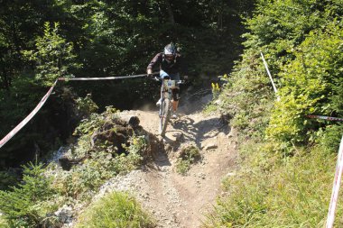 INNSBRUCK, AUSTRIA - 29 Ağustos 2015: Nordkette Alp dağ zincirinde Nordkette Downhill Pro yarışması sırasında tam donanımlı profesyonel motorcu dağ bisikleti sürüyor.