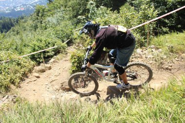 INNSBRUCK, AUSTRIA - 29 Ağustos 2015: Nordkette Alp dağ zincirinde Nordkette Downhill Pro yarışması sırasında tam donanımlı profesyonel motorcu dağ bisikleti sürüyor.