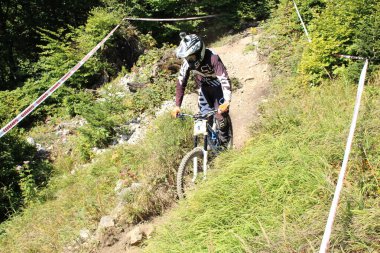INNSBRUCK, AUSTRIA - 29 Ağustos 2015: Nordkette Alp dağ zincirinde Nordkette Downhill Pro yarışması sırasında tam donanımlı profesyonel motorcu dağ bisikleti sürüyor.