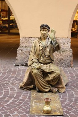 INNSBRUCK, AUSTRIA - 27 Temmuz 2015 'te Innsbruck' ta Herzog-Friedrich Caddesi 'nde Eski Şehir' de (Altstadt veya Altestadt) altın renkli Aladdin Cini kostümlü bir erkek animatör. 