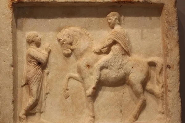 HERAKLION, CRETE, GREECE - 1 Ağustos 2016: İki adamın sohbet ettiğini gösteren mermer yardım plaketi, Roma Dönemi 1-2 sentine aittir. MS Heraklion Arkeoloji Müzesi 'nde.