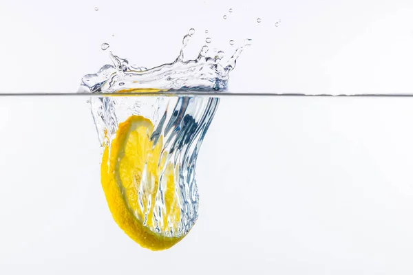 Amarillo limón fresco / cítrico en agua con salpicaduras de agua - Arte líquido —  Fotos de Stock