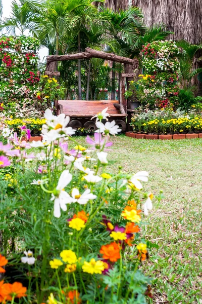 Chaise en bois dans un jardin fleuri confortable . — Photo