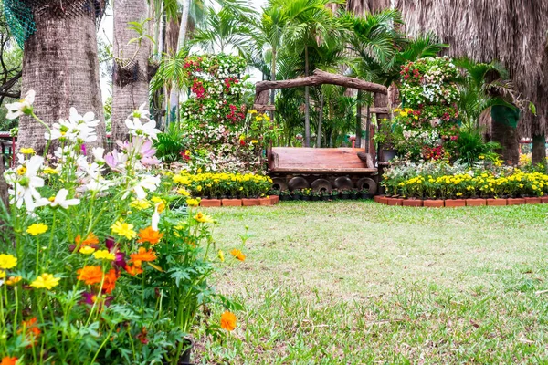 Chaise en bois dans un jardin fleuri confortable . — Photo