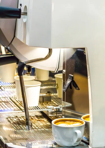 Espresso Machine pouring fresh coffee into cups at Local Coffee Shop.