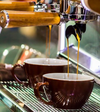 Espresso Machine 'in kahve makinesi yerel kahve dükkanında fincanlara taze kahve dolduruyor..