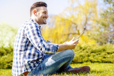 Açık havada müzik oturan genç adam