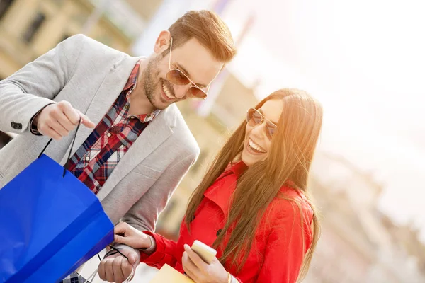 Joven pareja feliz con bolsas de compras en la ciudad —  Fotos de Stock