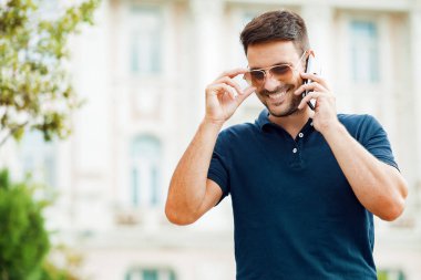 Genç adam telefonda konuşuyor.