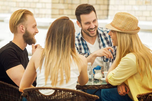 Glada unga människor njuter på ett café och kommunicera — Stockfoto