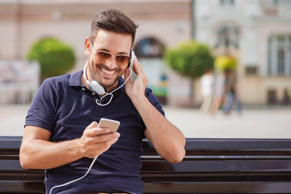 Joven escuchando música en un teléfono inteligente — Foto de Stock