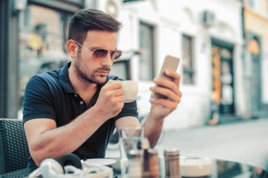 Kahve molası. Bir kafede oturan genç adam.