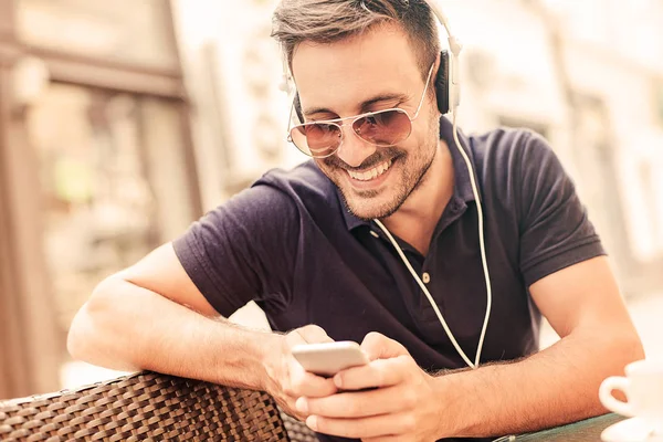 Joven escuchando música en un teléfono inteligente — Foto de Stock