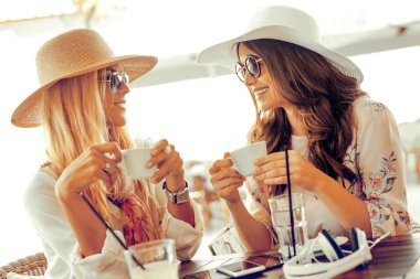 Kahve fincanı kafede birbirlerine bakarken tutan kadın