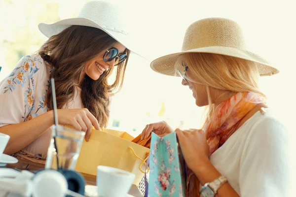 Dvě mladé ženy sdílení své nové nákupy s sebou — Stock fotografie