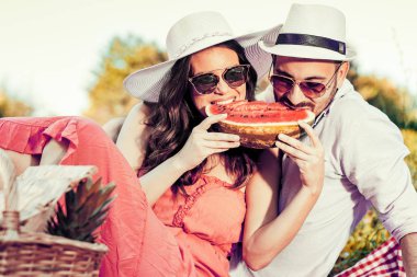 Mutlu çift karpuz yeme bir piknik üzerinde