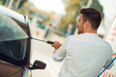 Araba yıkama. Genç adam arabasını Temizleme 