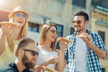 Kendi dilim pizza alarak arkadaş grubu