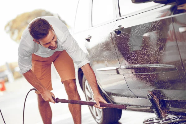 Mytí aut. Mladý muž čištění jeho auto — Stock fotografie