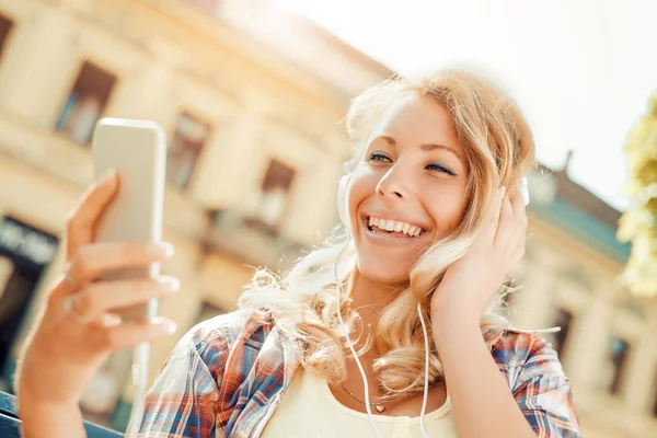 Mladá žena poslouchat hudbu na chytrý telefon — Stock fotografie