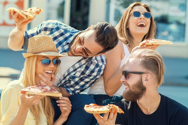 Glada grupp människor äter pizza utomhus — Stockfoto