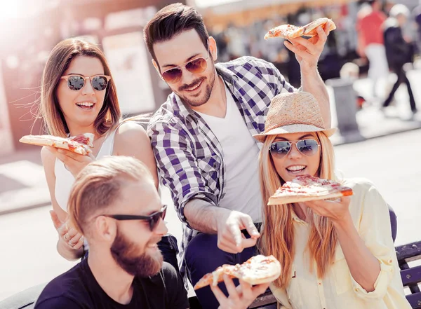 Grupp unga vänner äter pizza utomhus — Stockfoto