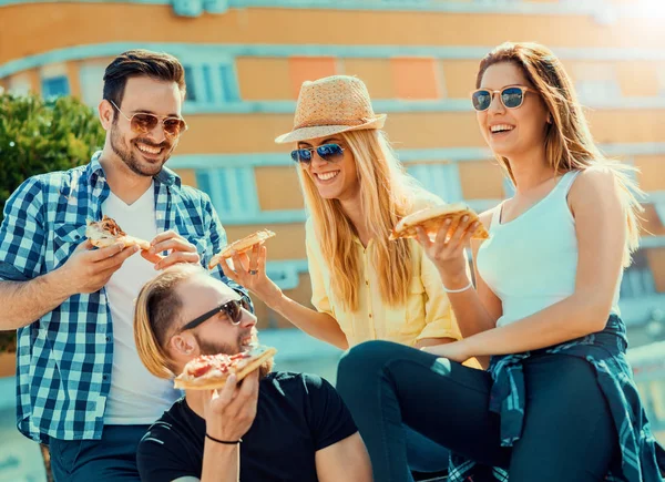 Grupp av vänner med deras bitar pizza — Stockfoto