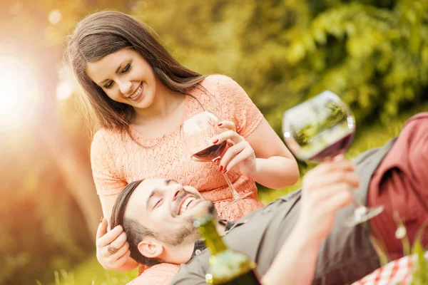 Cute young couple drinking red wine in park — Stock Photo, Image