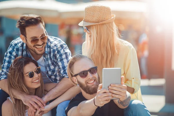 Grupp av fyra glada vänner tar selfie — Stockfoto