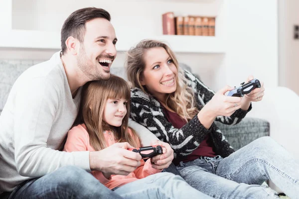Família feliz jogando um jogo de vídeo em casa — Fotografia de Stock